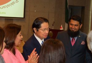 カディール氏(左)が日本・パキスタン友好議員連盟会長の衛藤氏(中央)に写真について説明している。右はサルマン・ババール臨時代理大使。